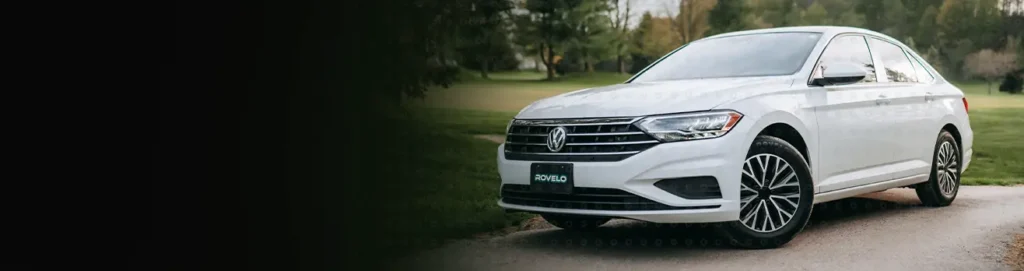 White car driving down road